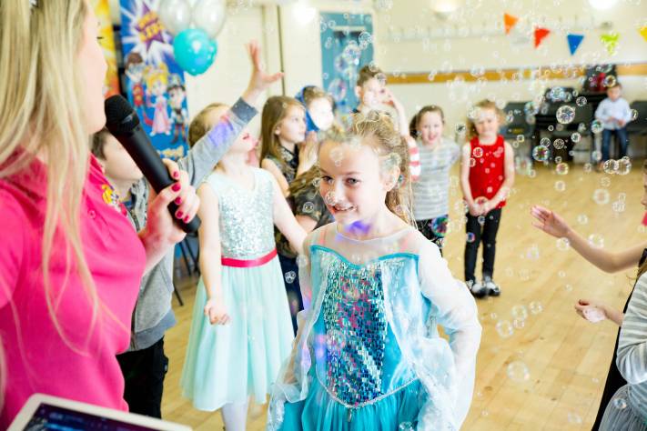 Birthday child speaking into entertainer's microphone