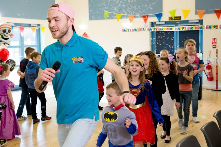 Entertainer leading children in dancing